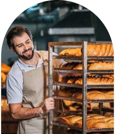 Baker looking at trays of bread and smiling